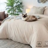 Gatito descansando sobre una cama tendida con el hermoso combo Caramelo Amare.